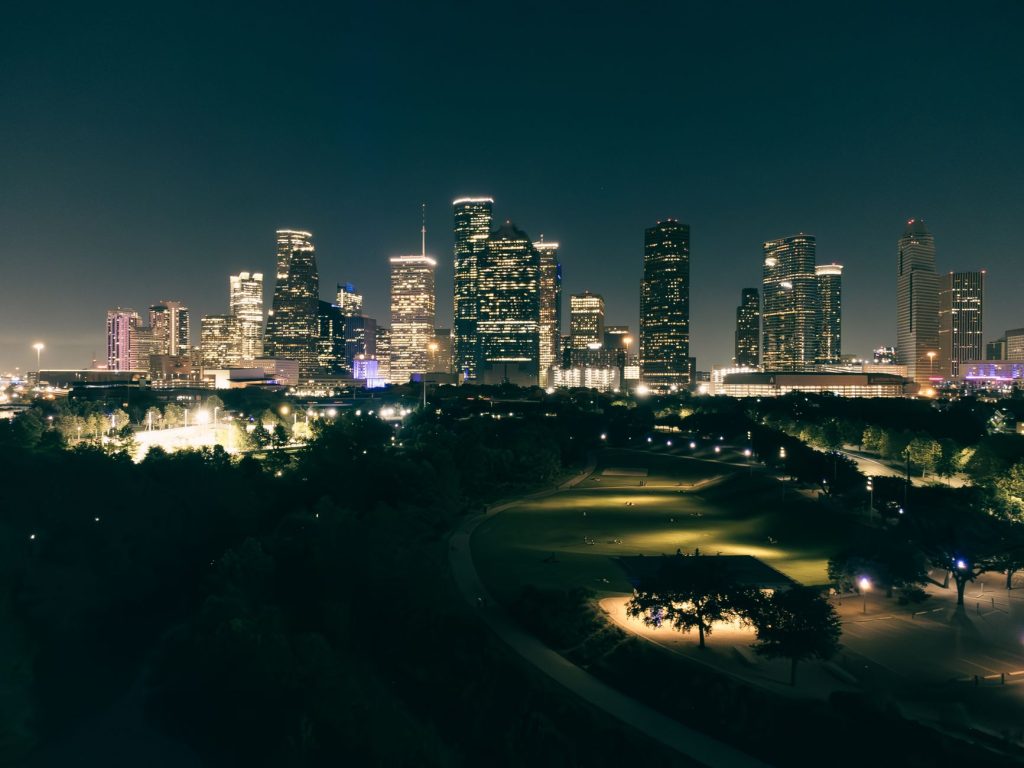 Stunning aerial view of Houston skyscrapers illuminated at night with vibrant city lights.