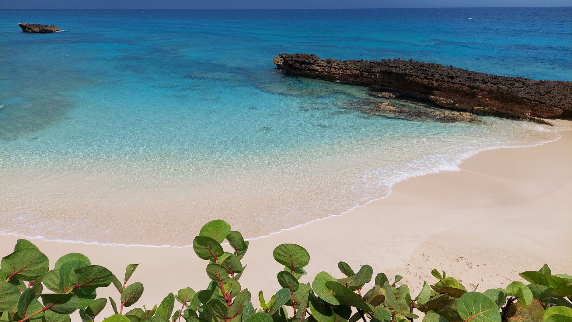 Explore a tranquil tropical beach with turquoise water and golden sand.