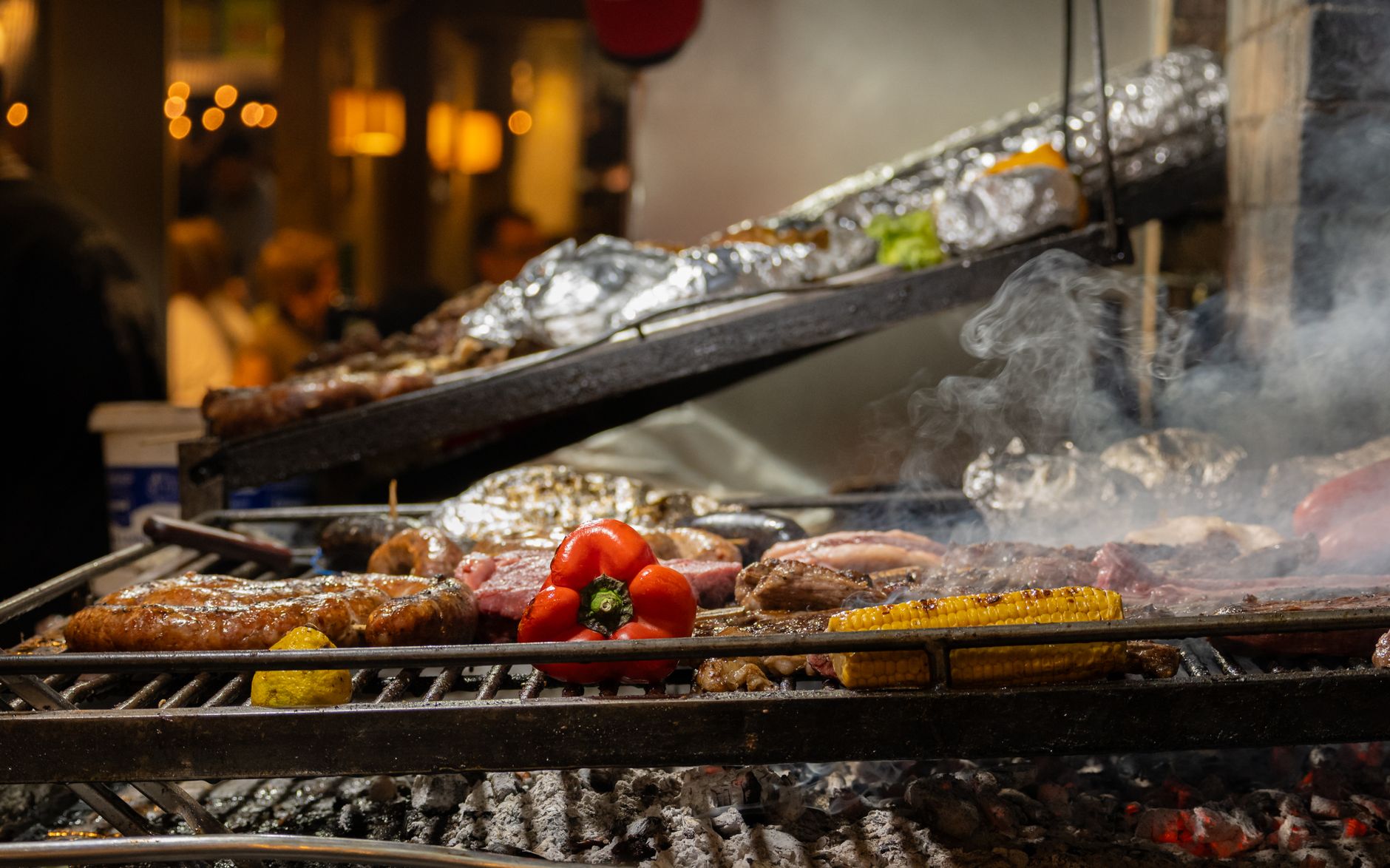 Delicious asado meats and vegetables sizzling on an open grill in Montevideo market.