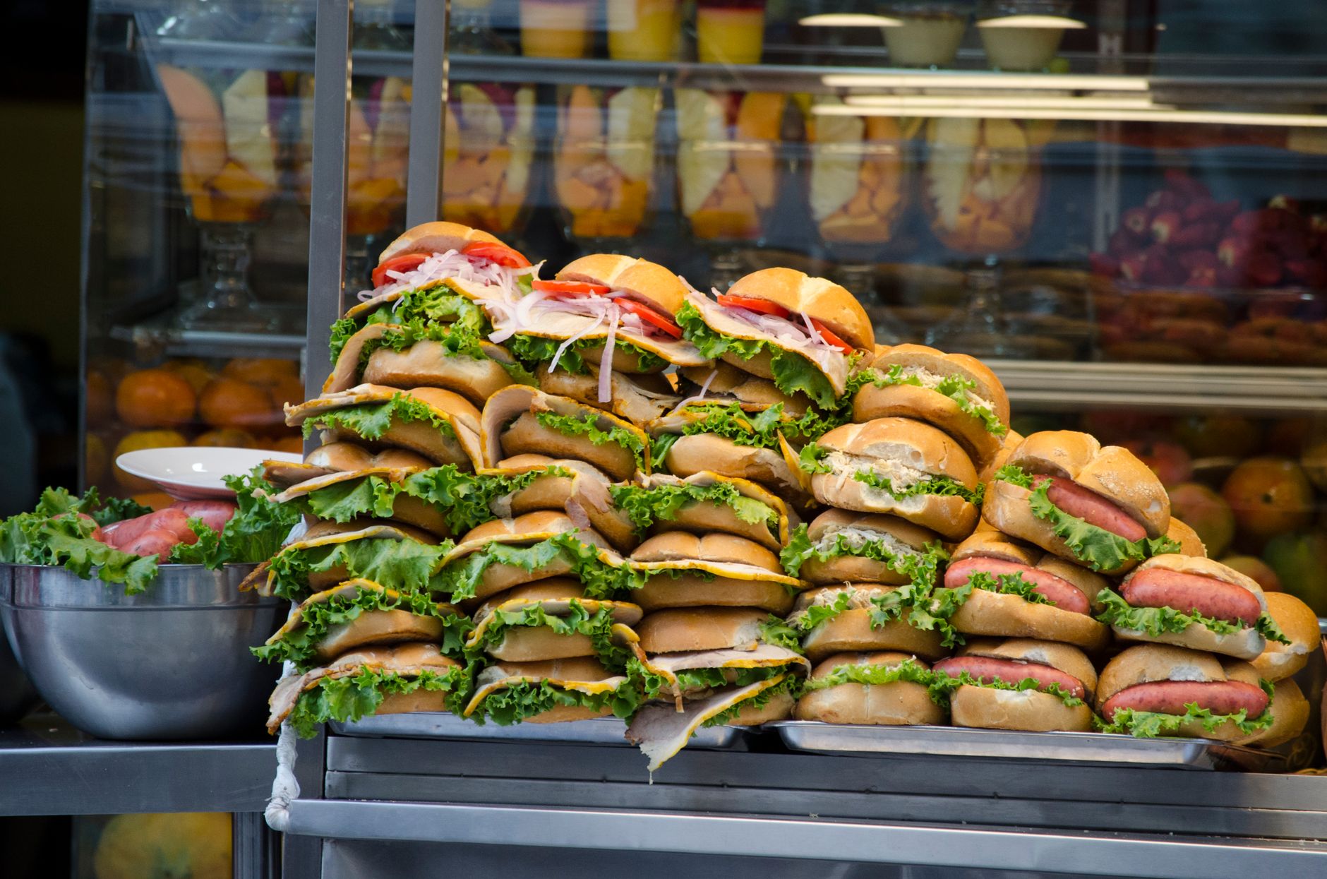 Vibrant stack of sandwiches with fresh lettuce and tomato in a busy street market of Lima, Peru.