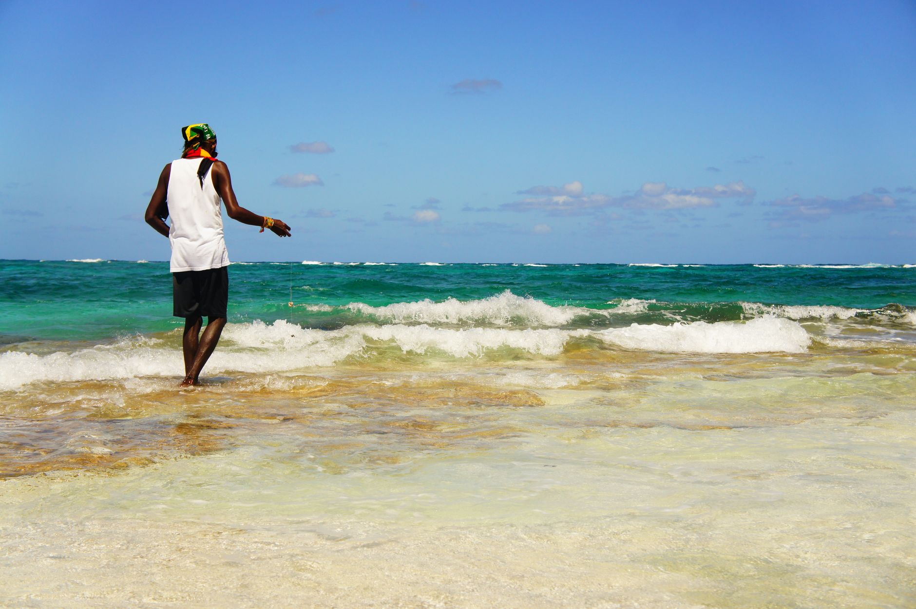 A lone fisherman casts his line in the clear blue waters at San Andrés, Colombia.