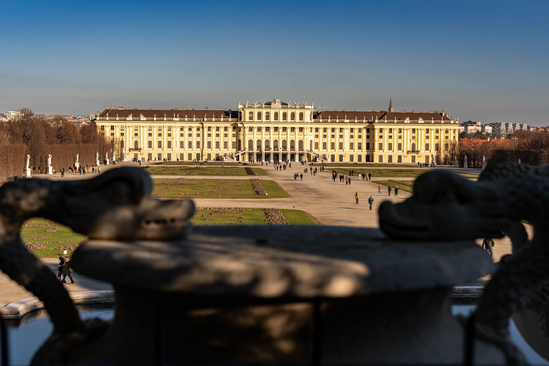 Stunning view of Schonbrunn Palace in Vienna captured from its gardens under a clear blue sky.
