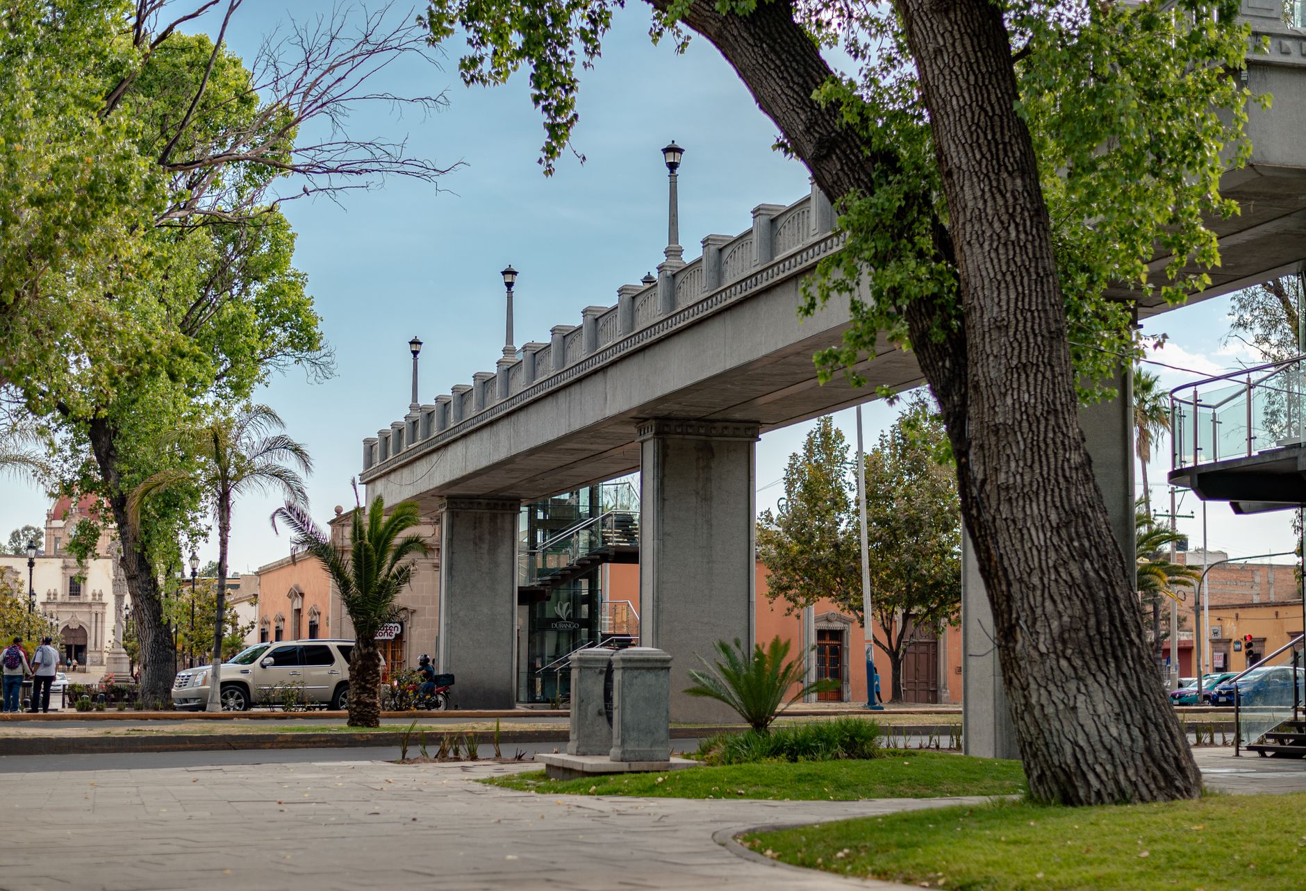 Scenic view of an urban footbridge surrounded by trees and buildings in Durango, Mexico.