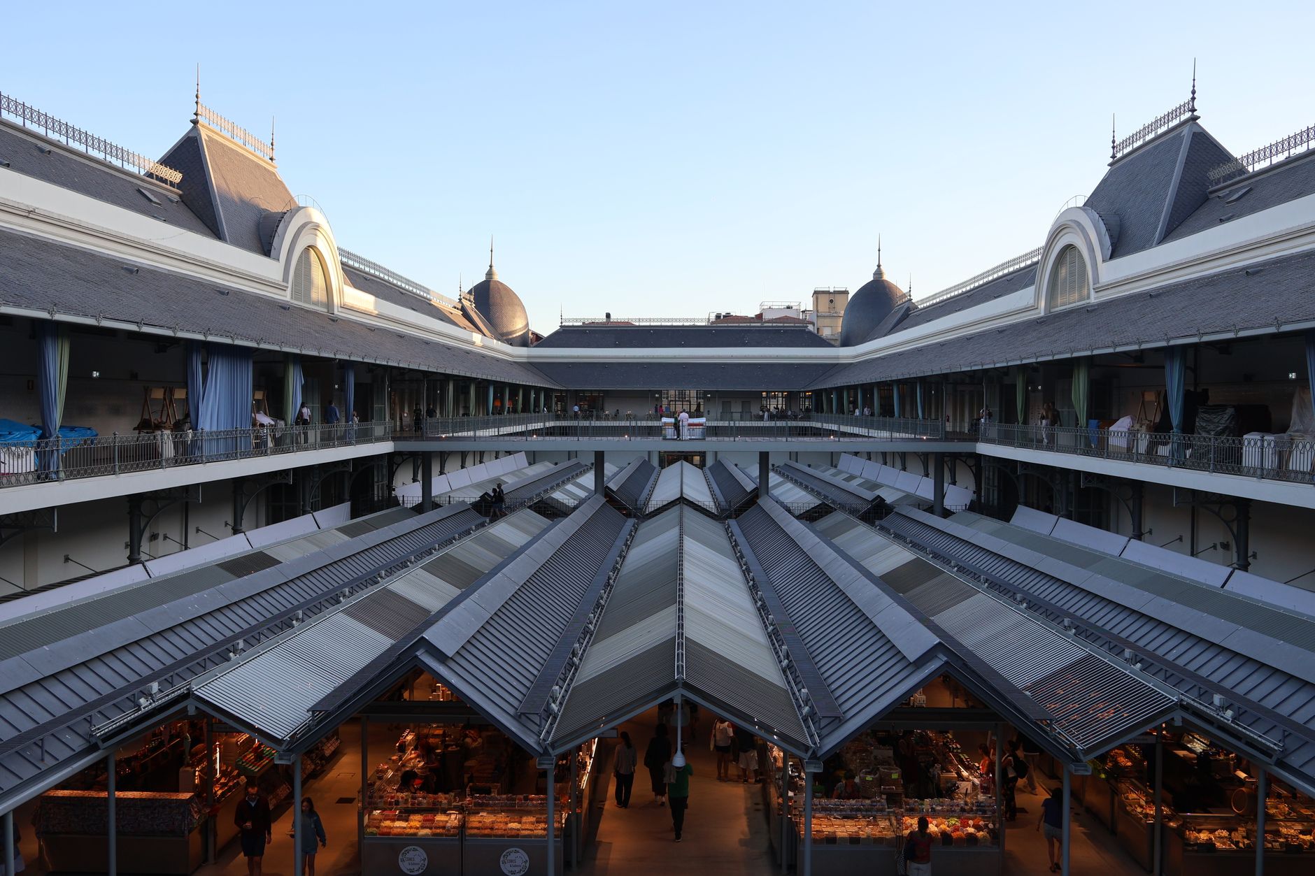 A spacious indoor market with classic architecture and high ceilings during day.