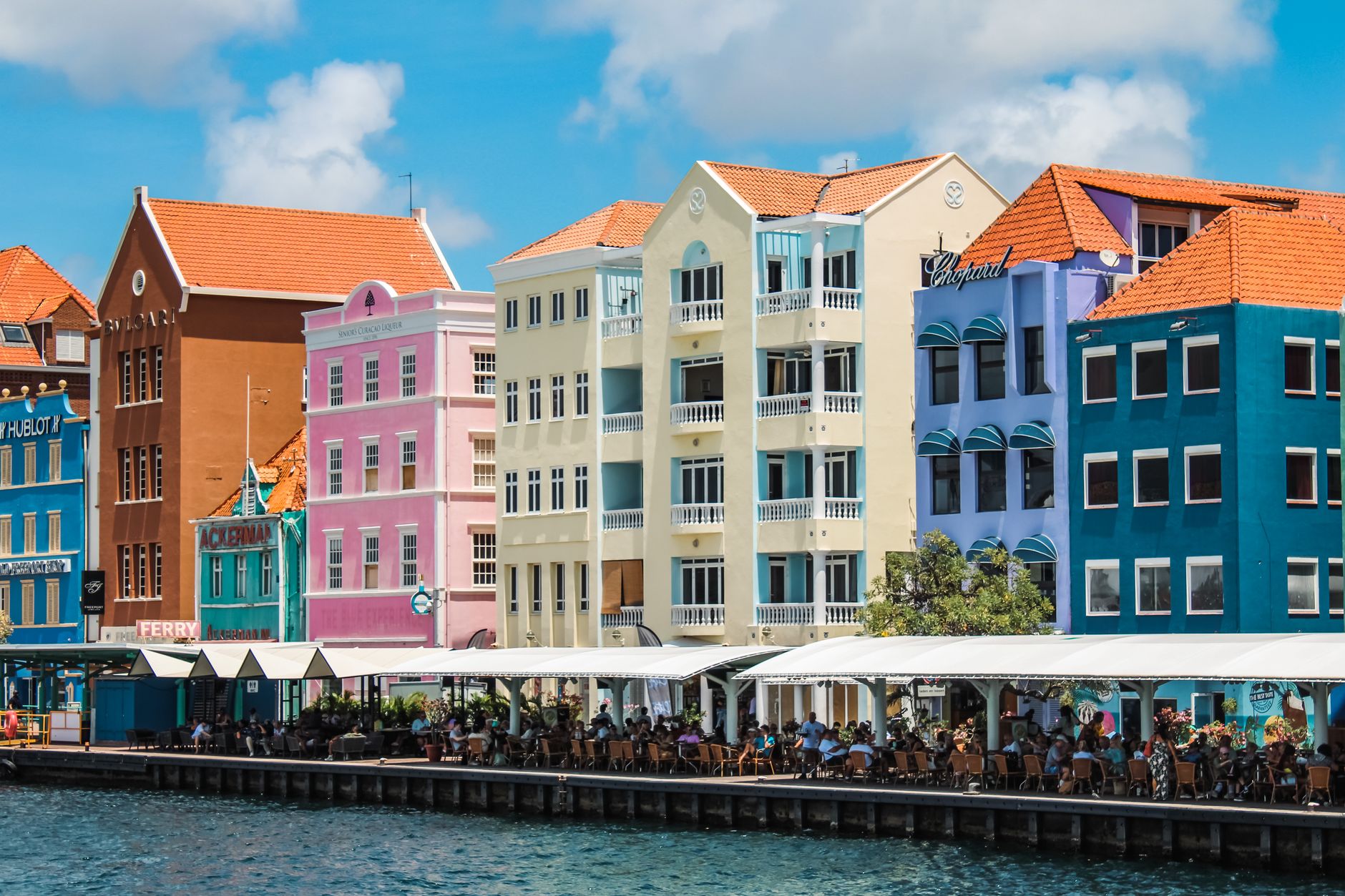Colorful buildings line the waterfront in Willemstad, Curacao, showcasing Dutch colonial architecture.