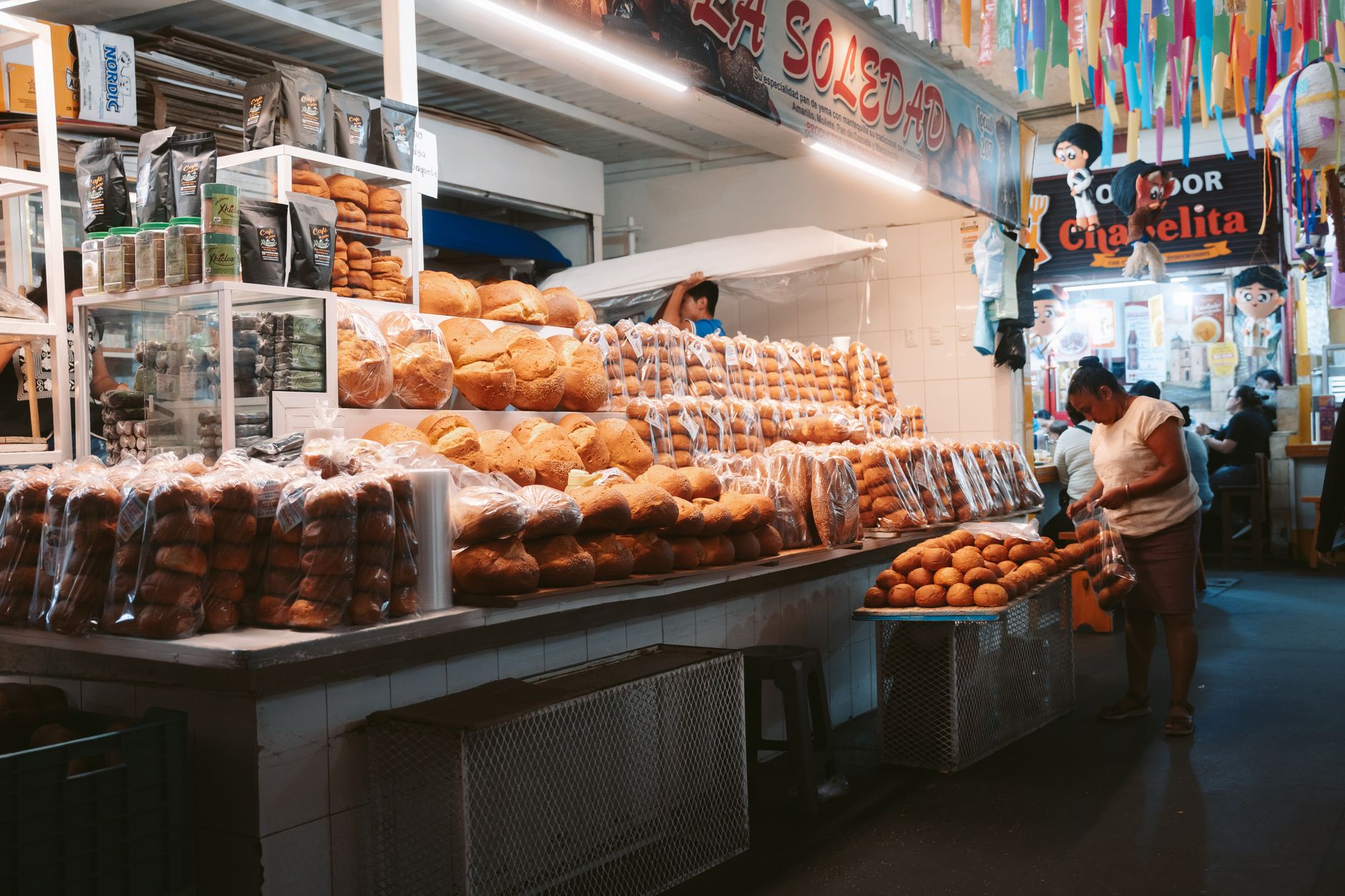 Explore the bustling bread market in Oaxaca de Juárez, filled with diverse baked goods and local culture.