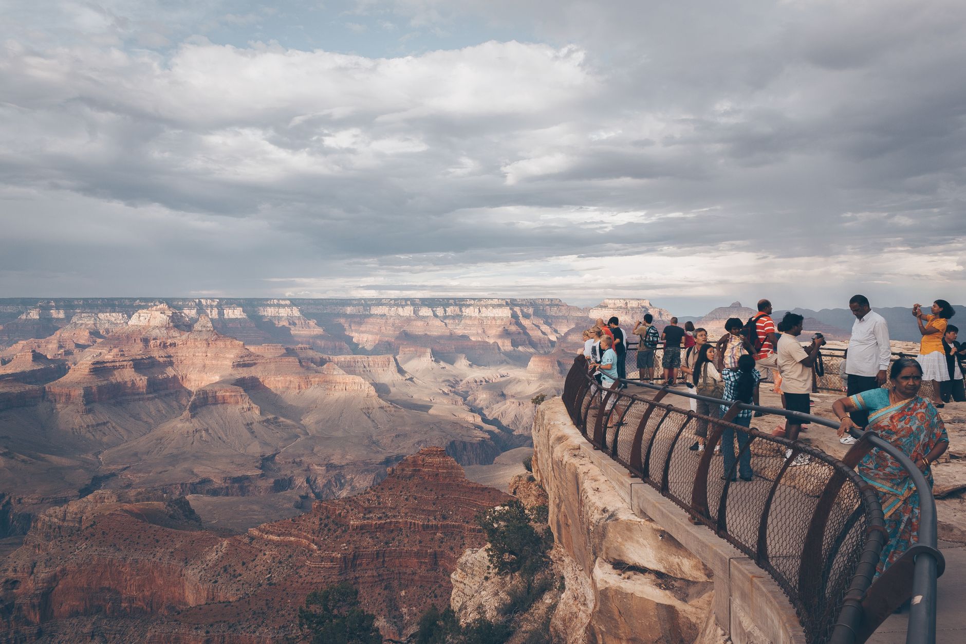Visitors overlook the breathtaking landscape of the Grand Canyon at sunset.
