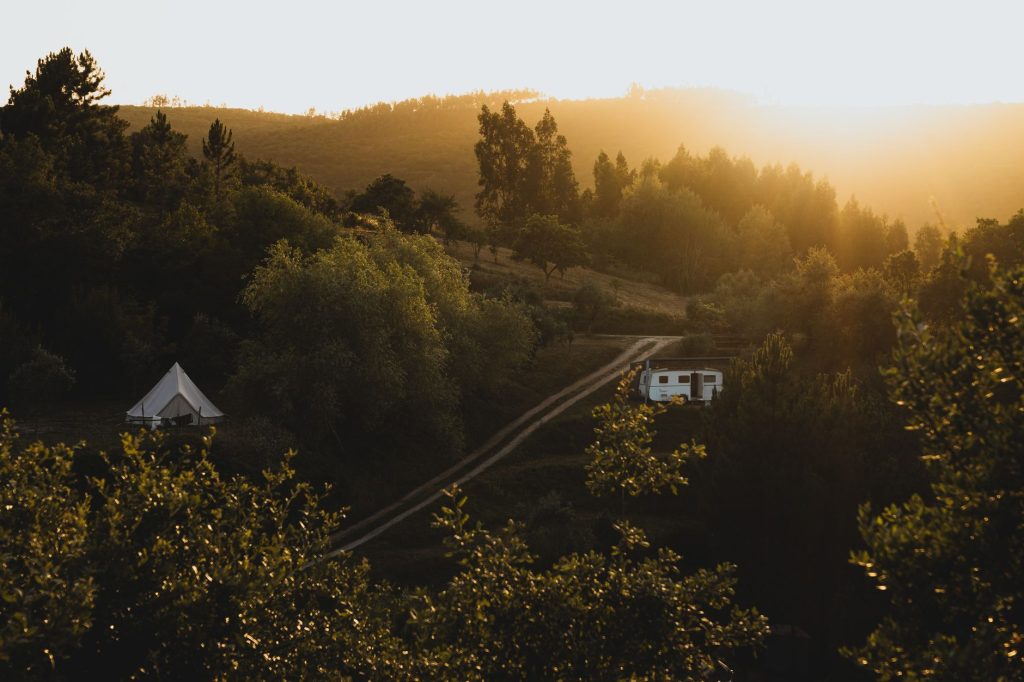 Explore the serene beauty of a campsite at sunset in Portugal's lush countryside.