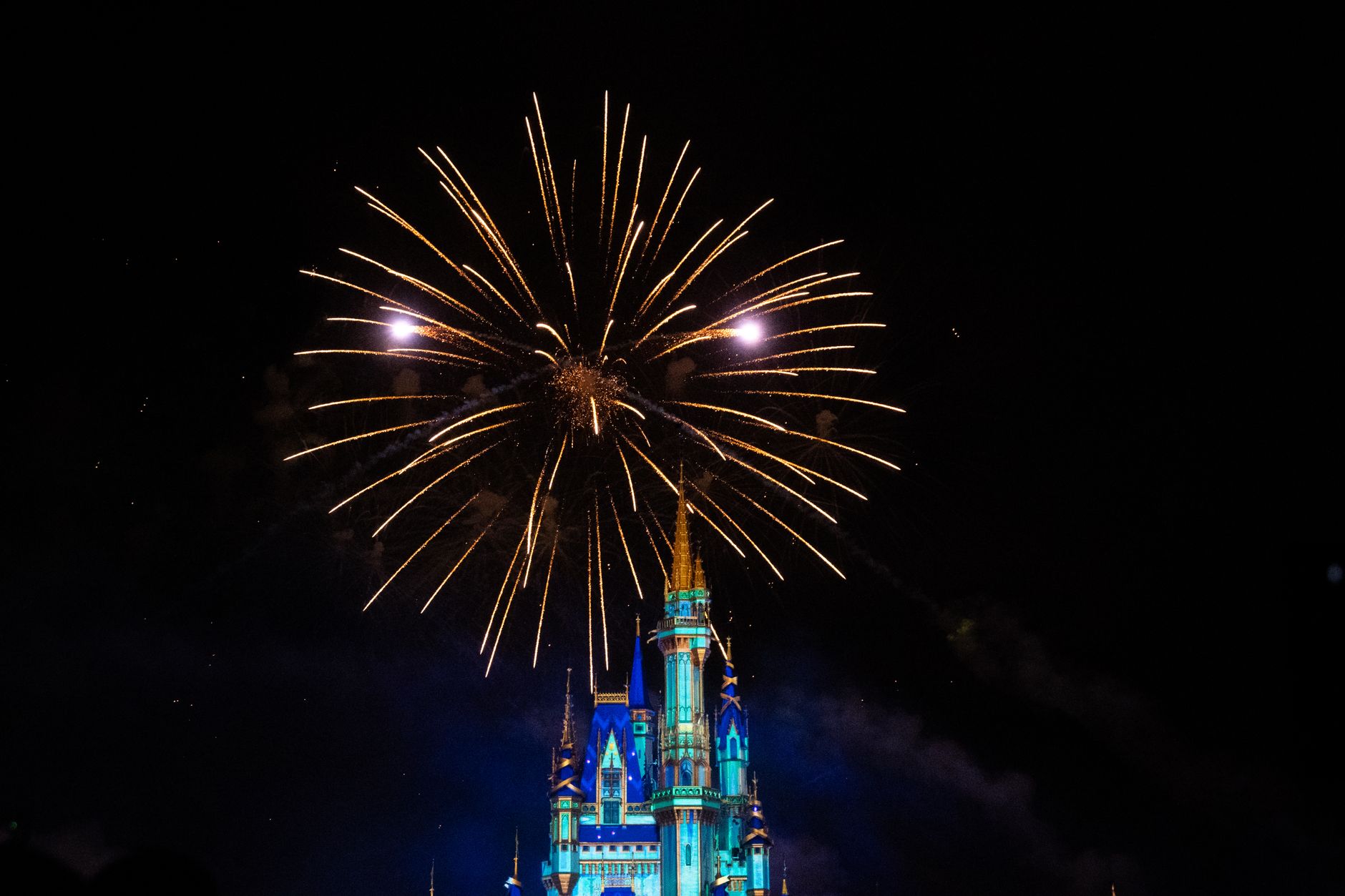 Stunning fireworks display over an illuminated castle at night, showcasing celebration and magic.