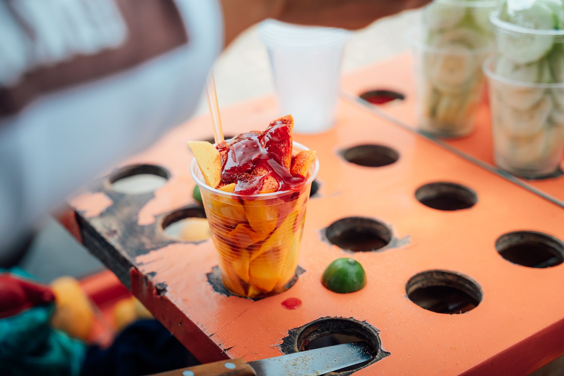 Vibrant street food scene with sliced mango topped with syrup, captured in Ciudad de México.