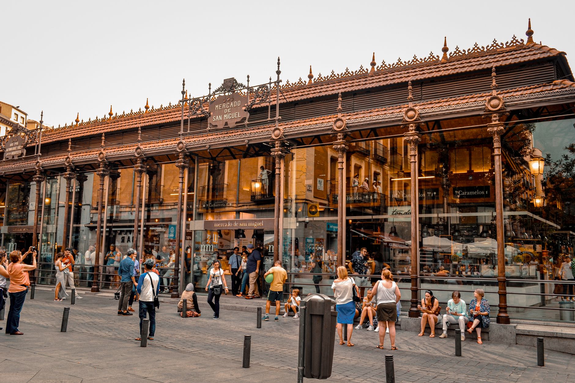Bustling activity at Mercado de San Miguel in Madrid, a popular tourist spot with iconic architecture.