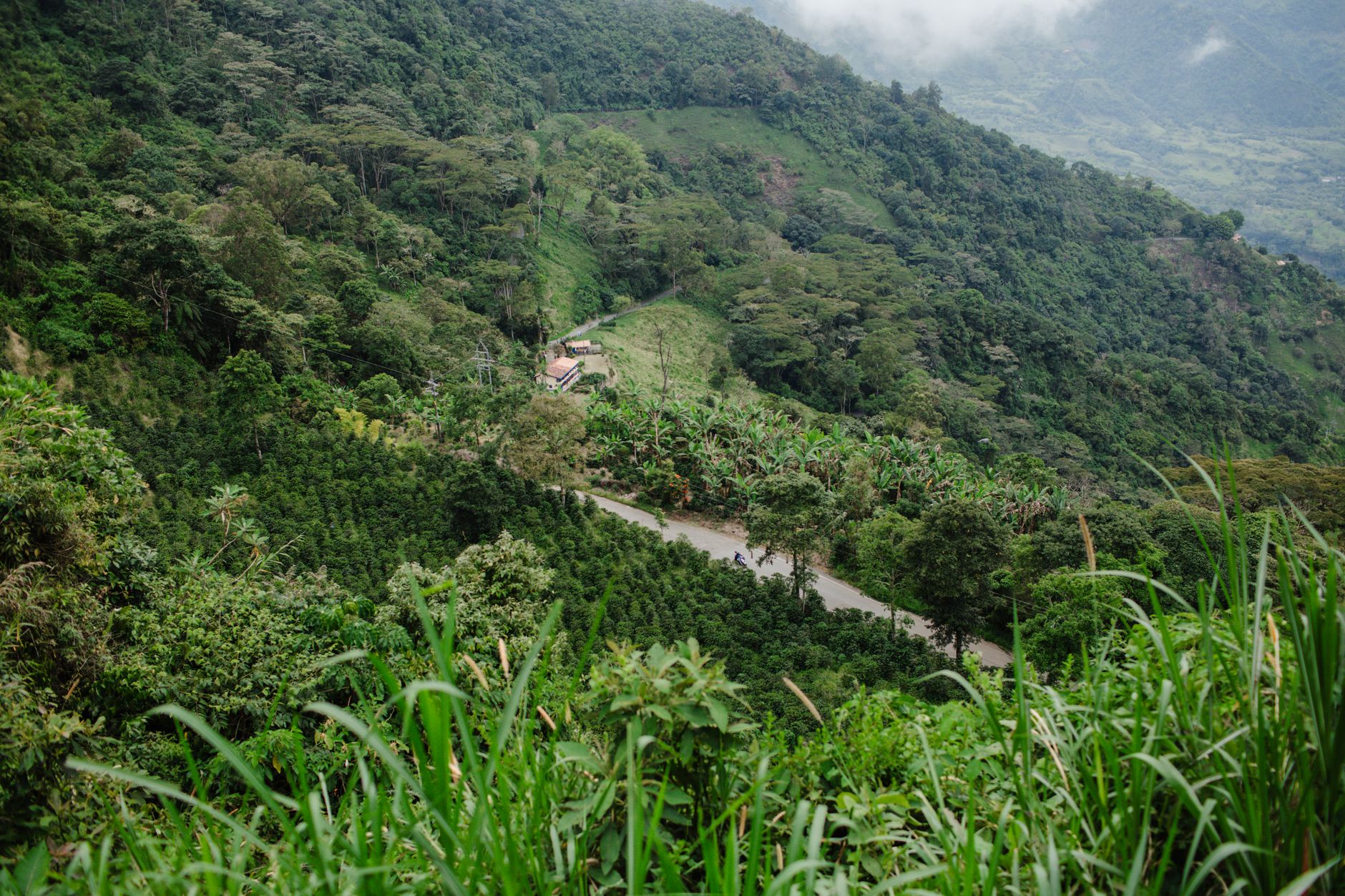 Stunning aerial view of lush green mountains and farm in Jericó, Antioquia, Colombia.