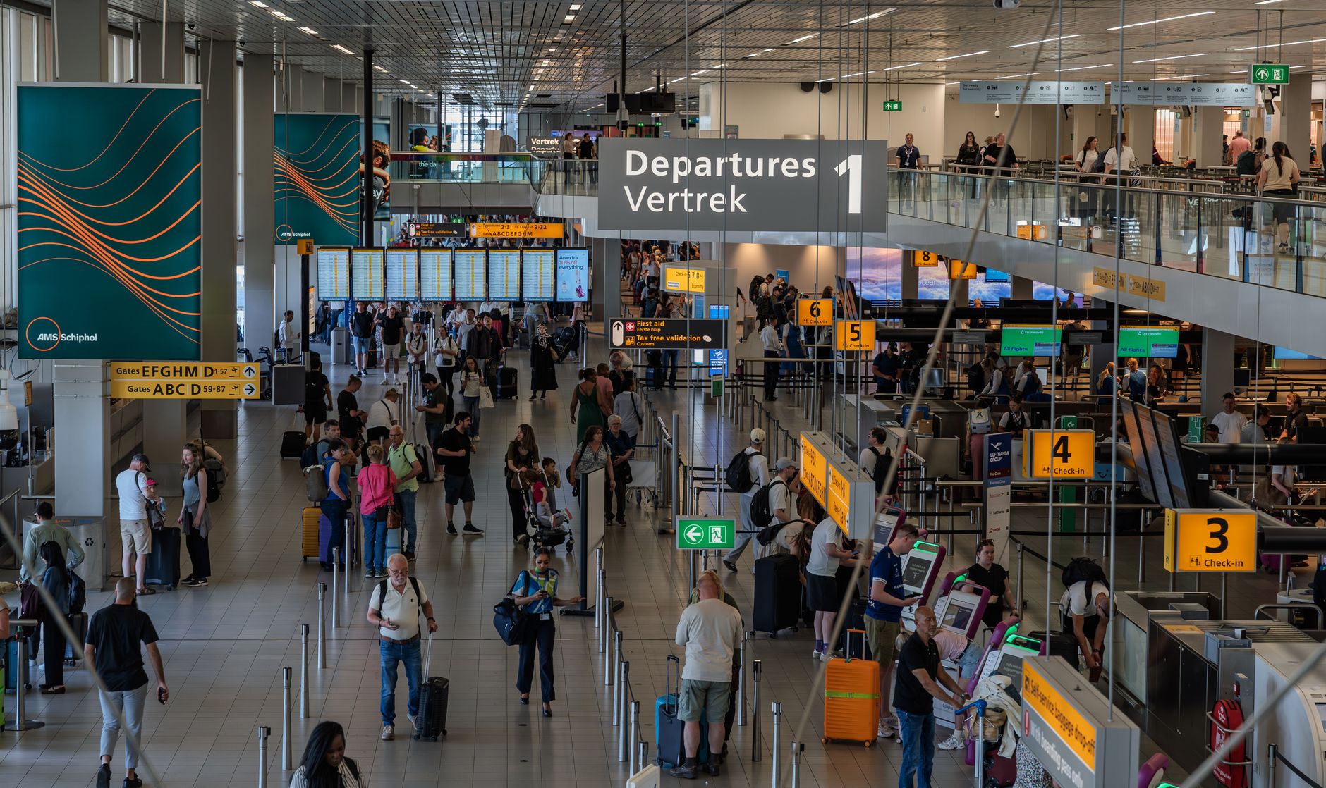 Crowds in the departure area of Amsterdam's Schiphol Airport, showcasing bustling travel activity.