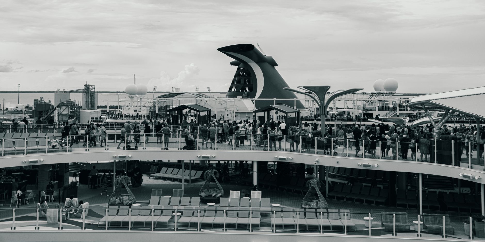 Black and white view of a busy cruise ship deck with passengers in The Bahamas.