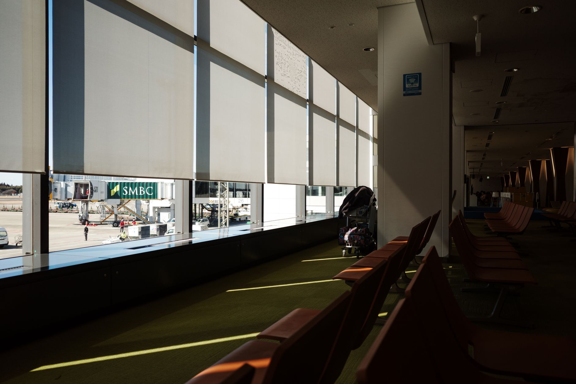 Empty airport terminal seating area with sunlight streaming in, showcasing a peaceful atmosphere.