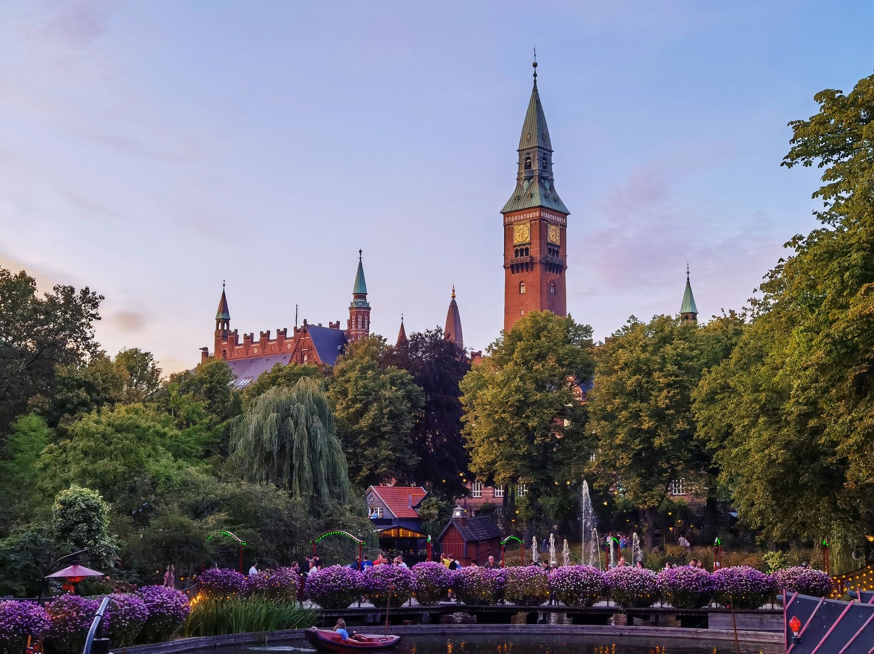 Scenic view of historic tower and gardens in warm evening light, capturing serene ambiance.