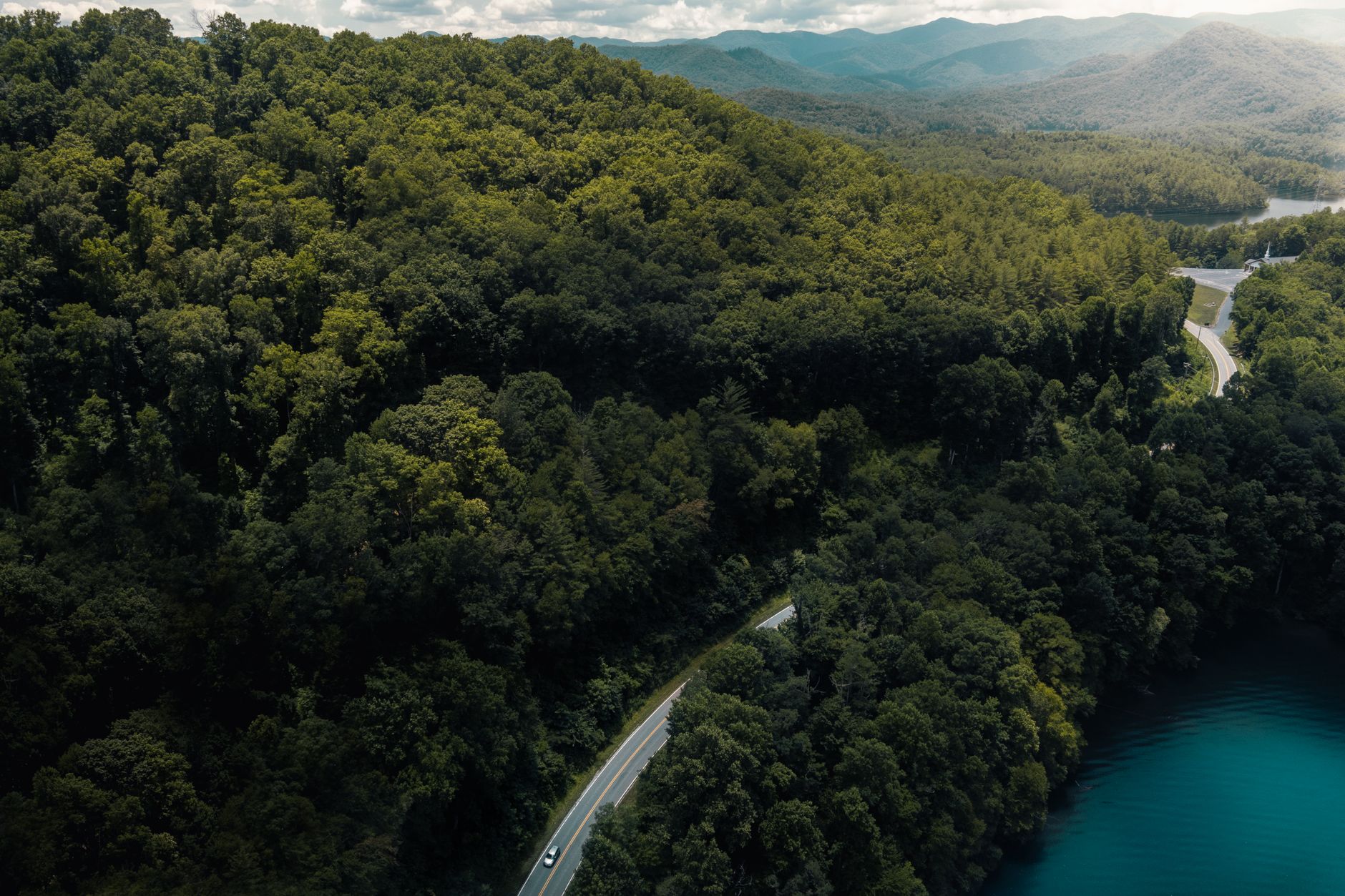 Stunning aerial shot of a winding road through lush forests in Gatlinburg, Tennessee, showcasing nature's beauty.