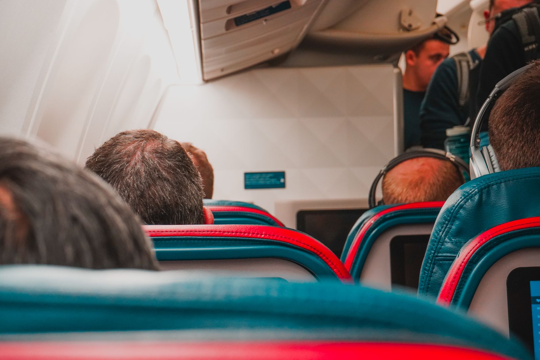 Interior view of an airplane cabin with passengers seated, focusing on seats and layout.