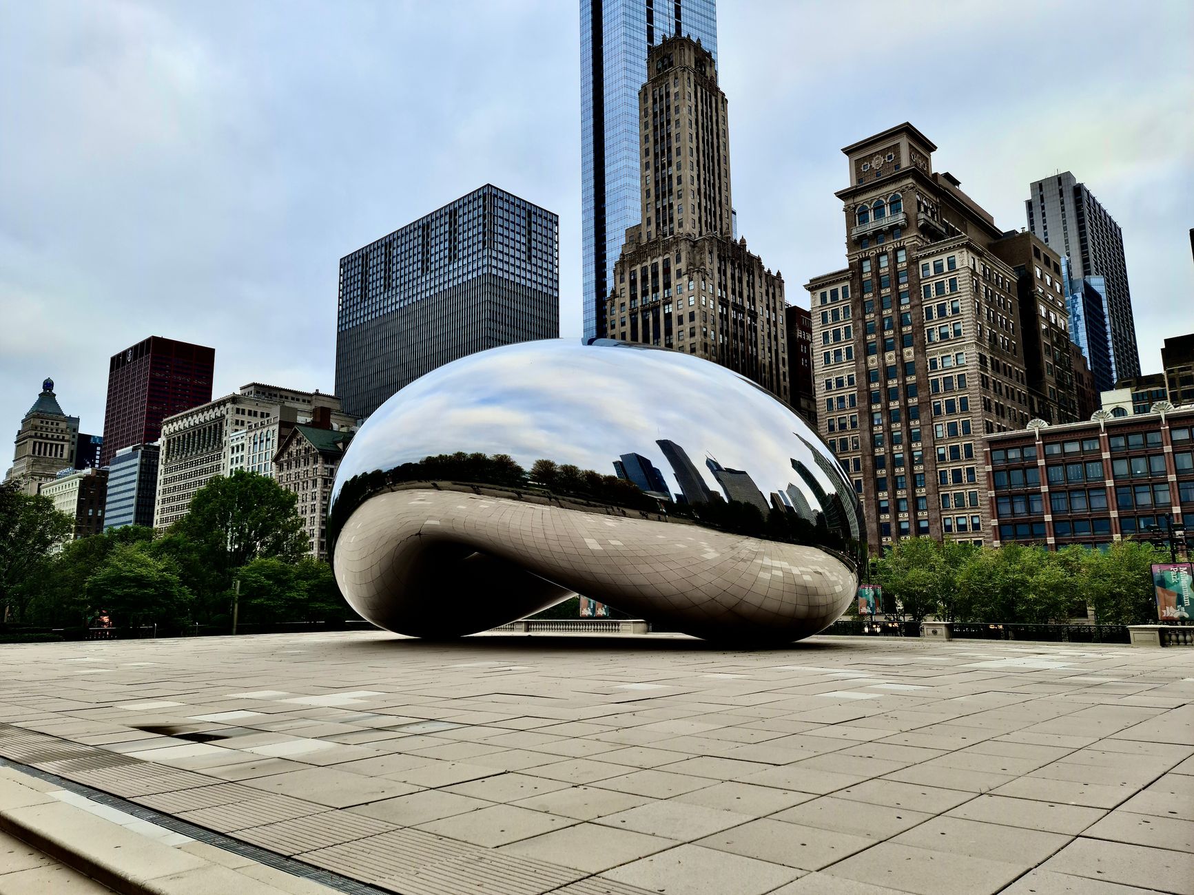 The reflective Cloud Gate sculpture in Chicago surrounded by iconic skyscrapers.