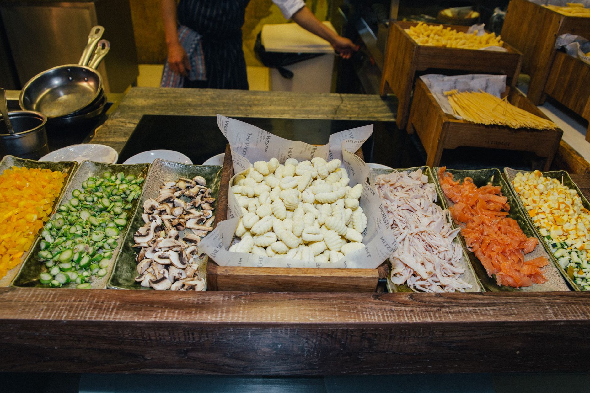 A colorful selection of fresh vegetables and pasta ingredients on display at a bustling food market.