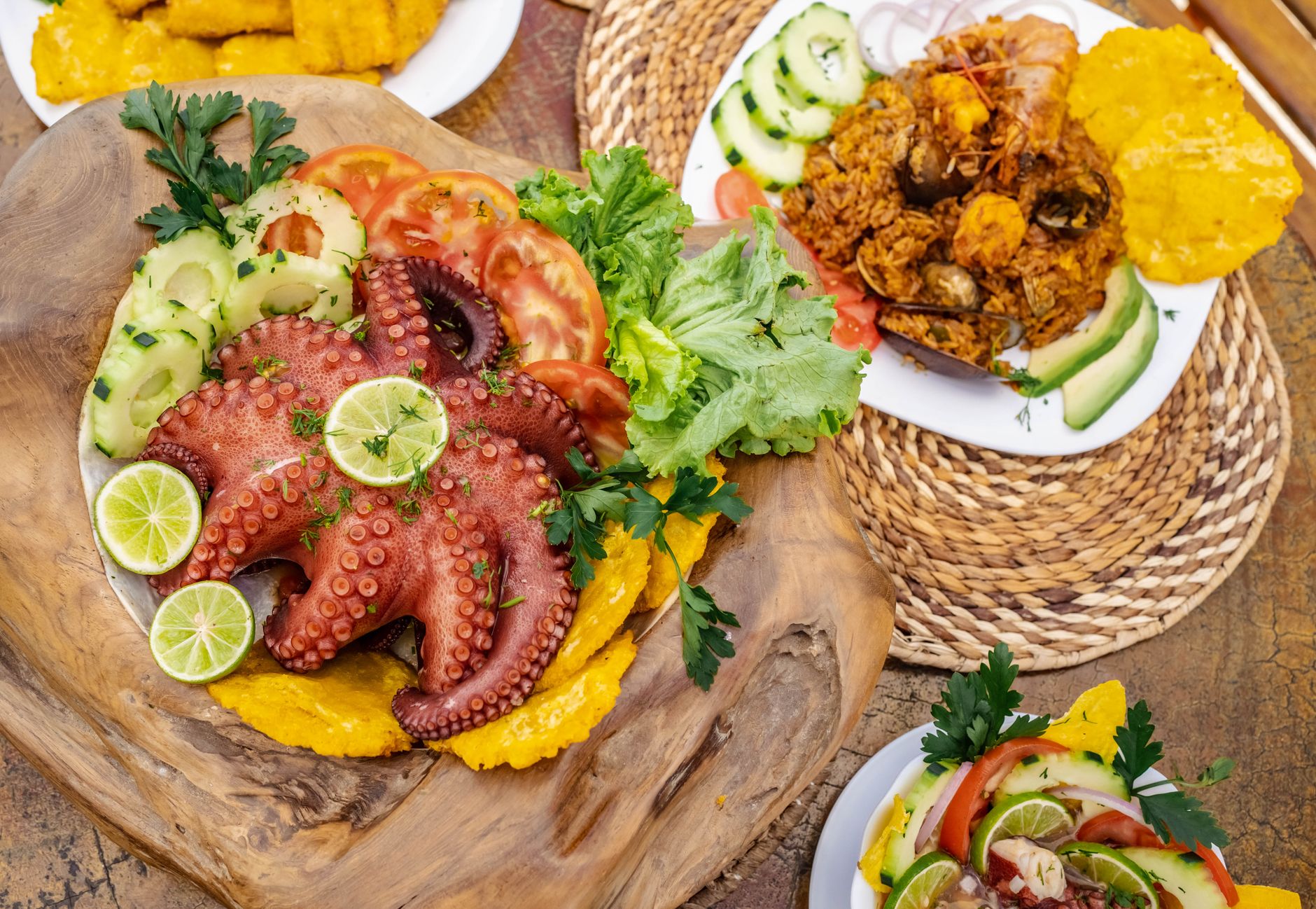 Delicious seafood platter with octopus and vegetables, presented on a rustic wooden board.
