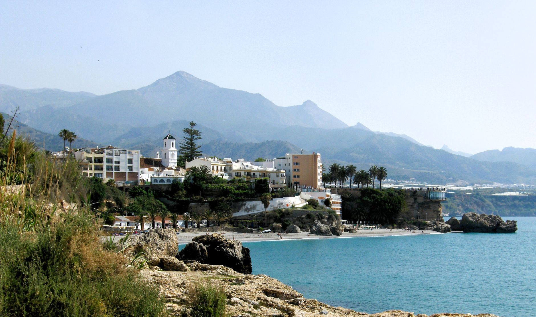 Picturesque coastal town of Nerja with stunning mountains and clear blue sea.