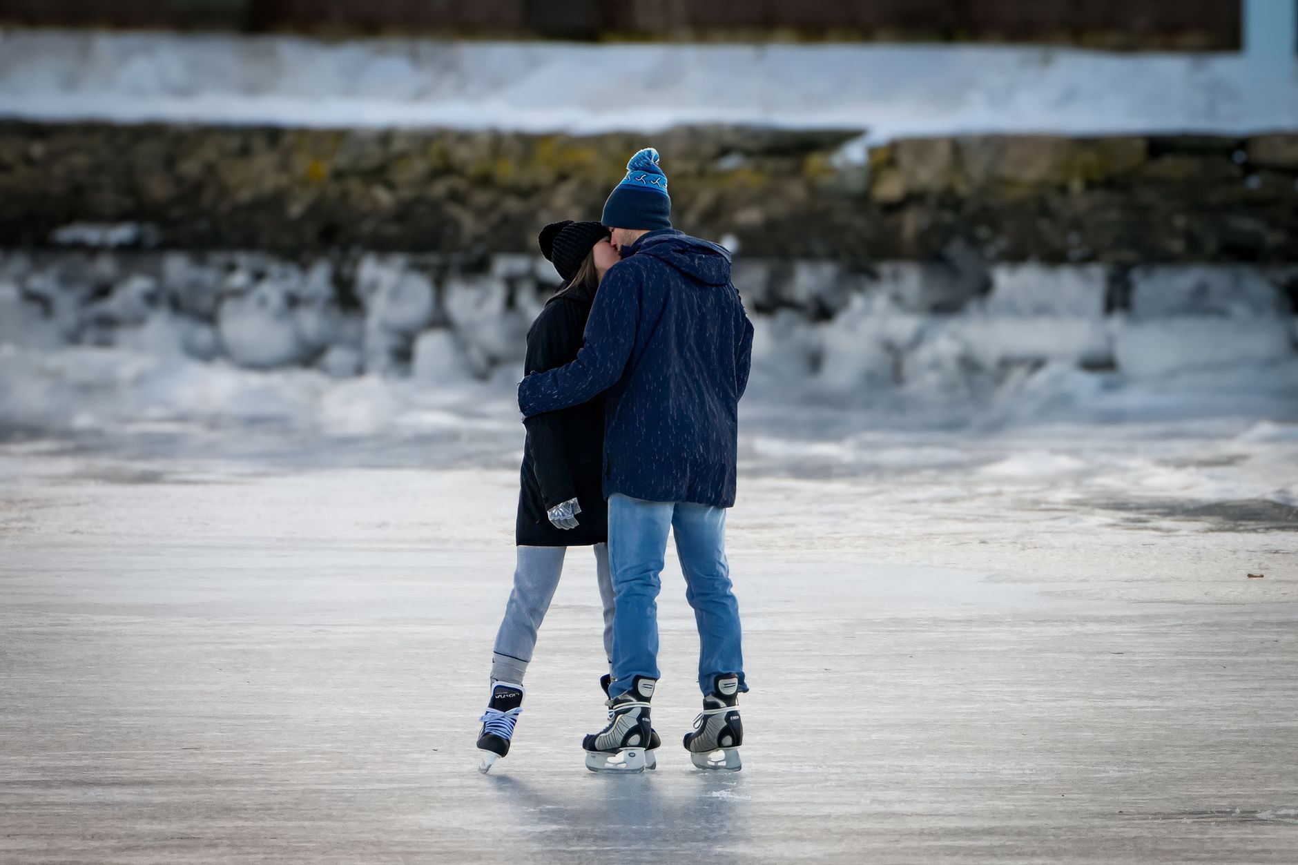 A couple enjoys ice skating on a frozen lake, embracing the winter outdoors.