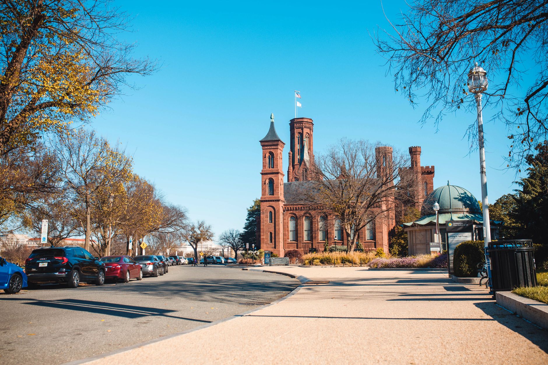 The iconic Smithsonian Castle in Washington, DC captured on a clear, sunny day with vibrant fall foliage.