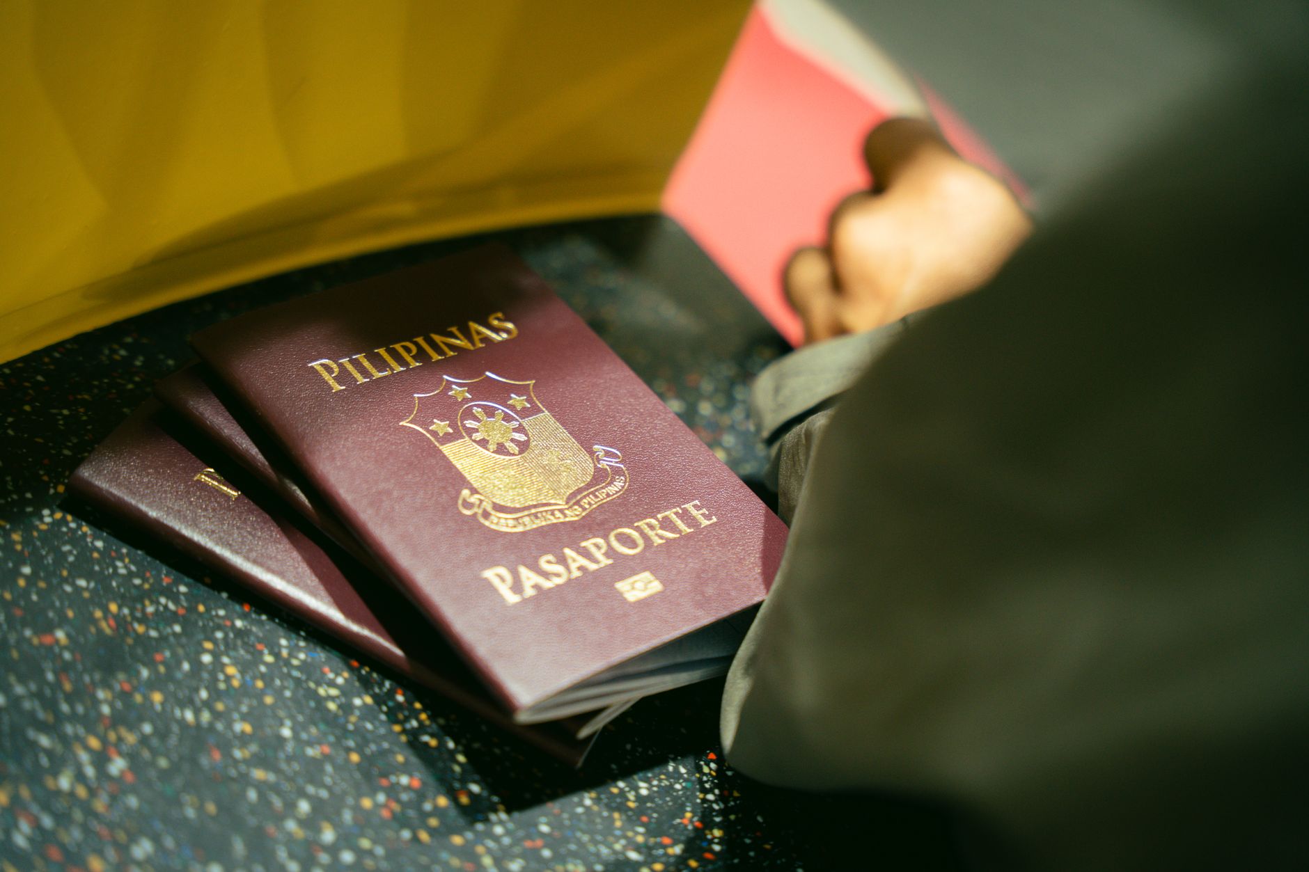 A close-up shot of Filipino passports at the airport, indicating travel and identity.