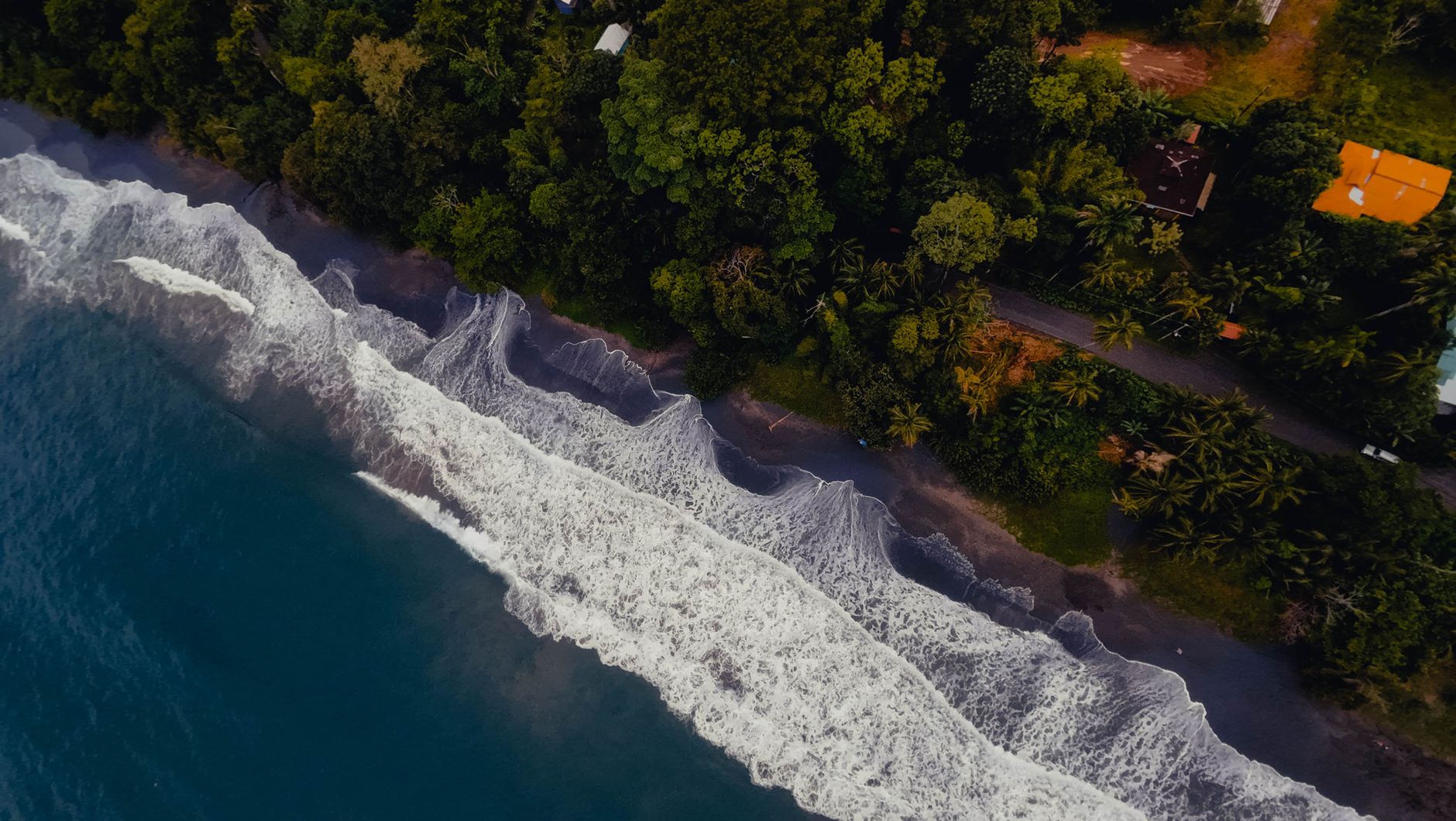 A breathtaking aerial view of the coast of Puerto Viejo de Talamanca, Costa Rica, showcasing lush greenery and ocean waves.
