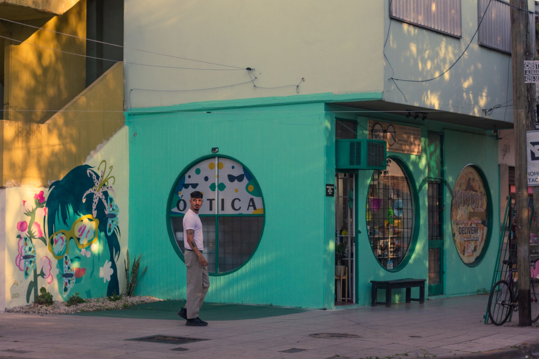 Colorful mural and street scene at an optical shop in Buenos Aires, creating a lively urban atmosphere.