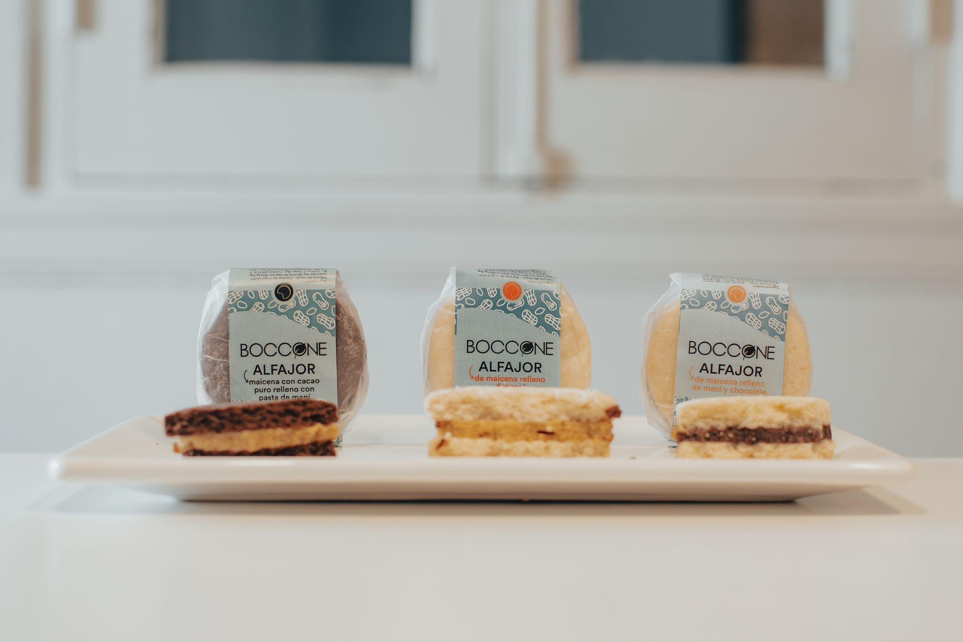 Close-up of three assorted alfajores on a plate, showcasing gourmet dessert packaging.