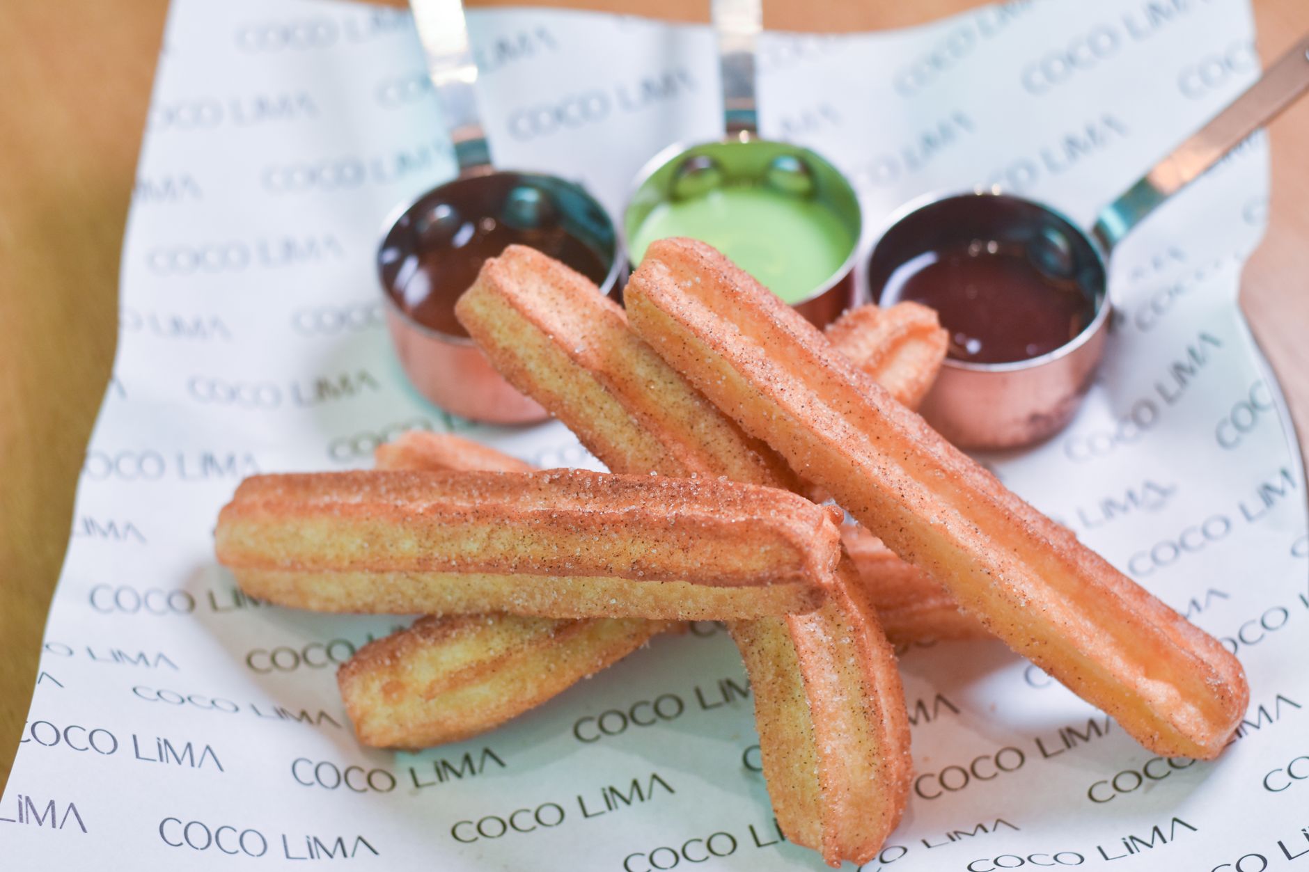 Close-up view of fresh churros with sauces, ideal for dessert lovers and food photographers.