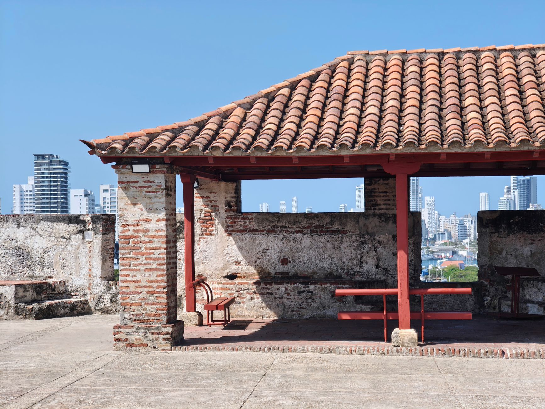 Colonial architecture meets modern skyline in Cartagena, Colombia. Captured outdoors on a sunny day.