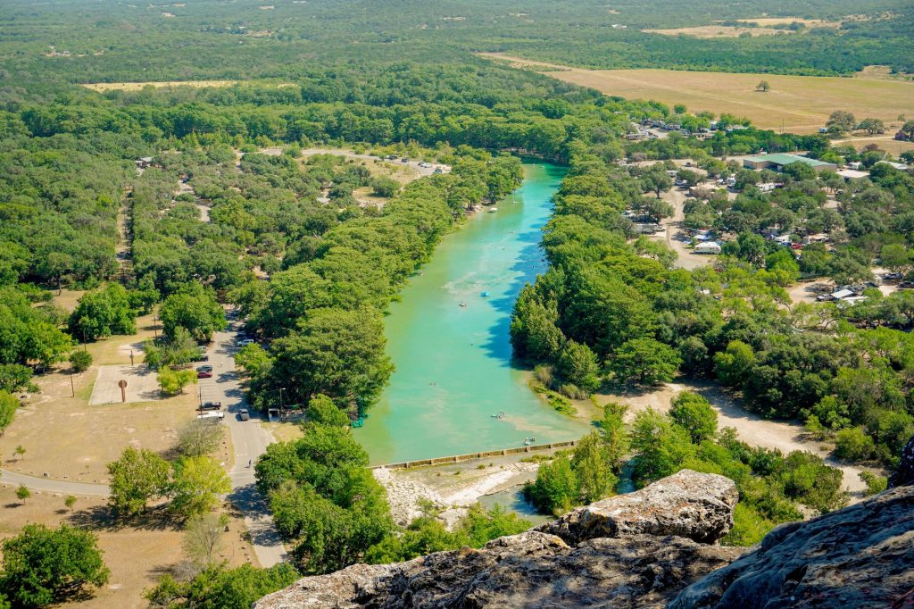 Scenic aerial shot of Frio River surrounded by lush greenery in Concan, Texas.