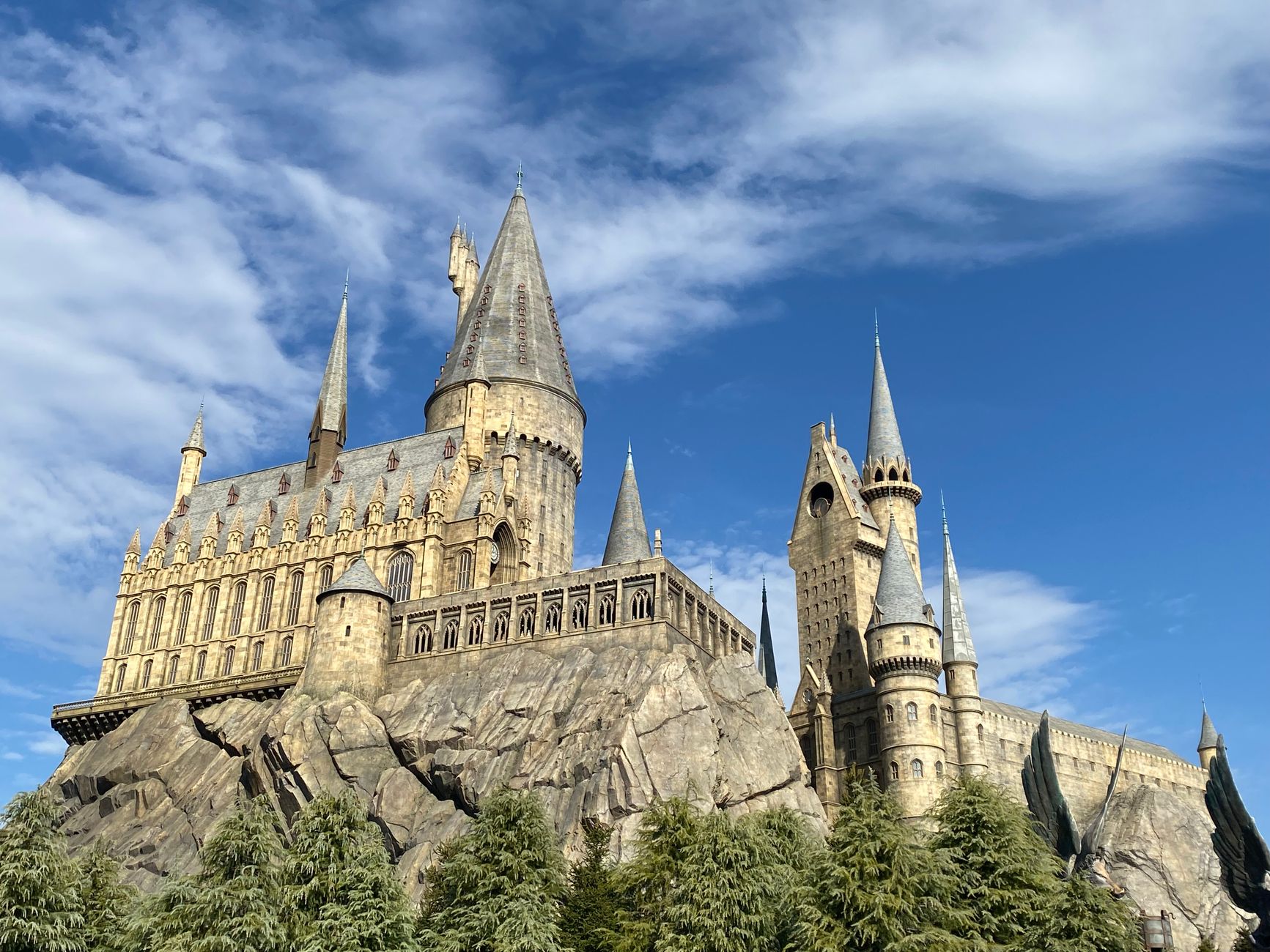 The iconic Hogwarts Castle at Universal Studios Japan's Wizarding World against a bright blue sky.