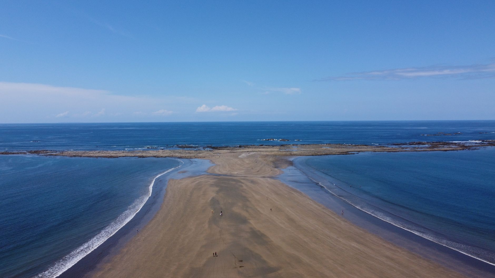 Stunning aerial view of Ballena Beach in Puntarenas, Costa Rica with clear blue skies and ocean.