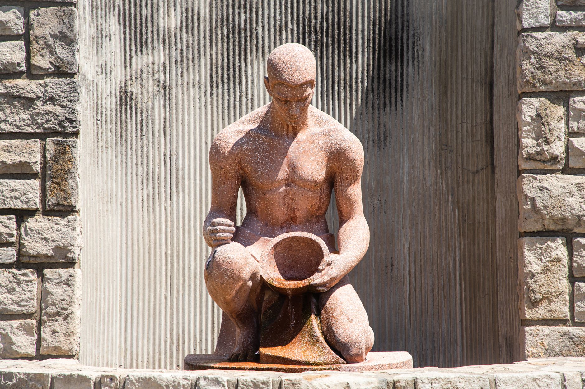 A striking male statue made of stone, located in Loose Park, Kansas City.